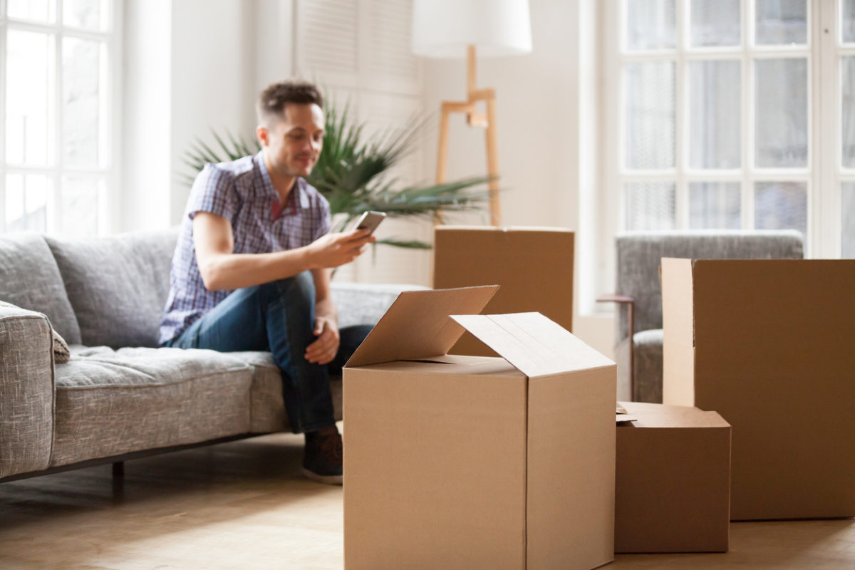 Man sitting on a couch in a living room facing foreclosure in Kansas City.