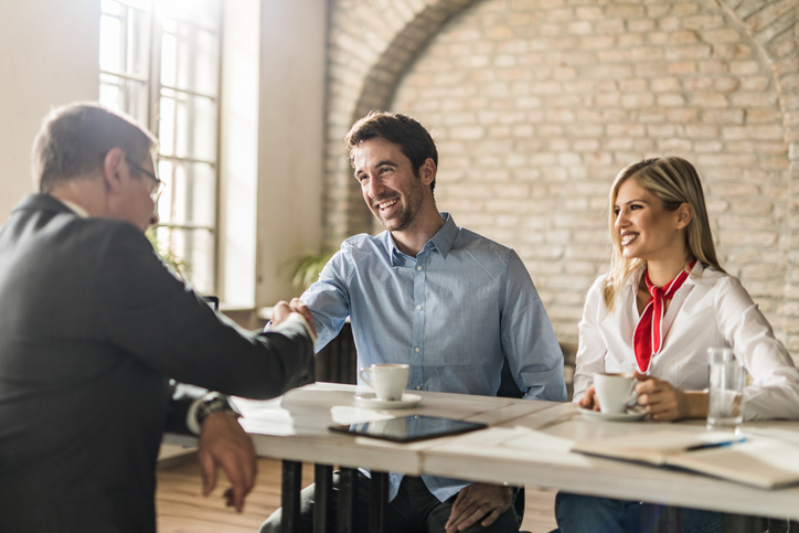 A young couple meeting with a cash buyer to sell their home quickly in Kansas City to relocate.